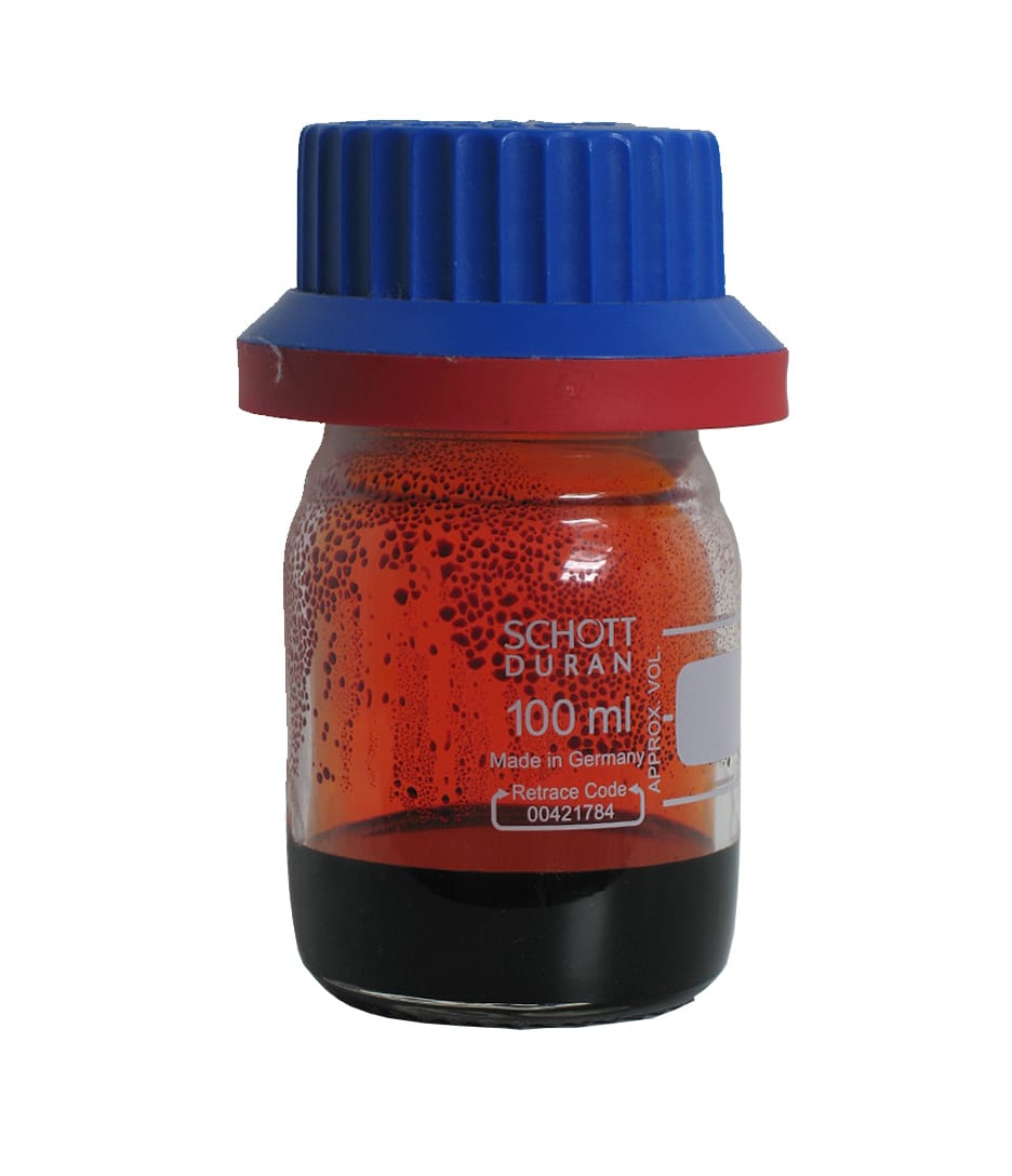 A small glass bottle with a blue cap holding a dark red-brown liquid at the bottom and orange-red vapour filling the space above