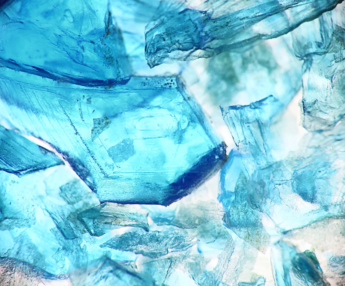 Close-up of large, clear, bright blue crystals packed together
