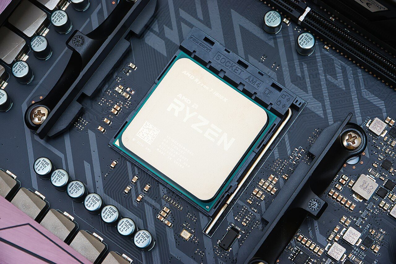 A square processor chip sitting in its socket on a computer motherboard