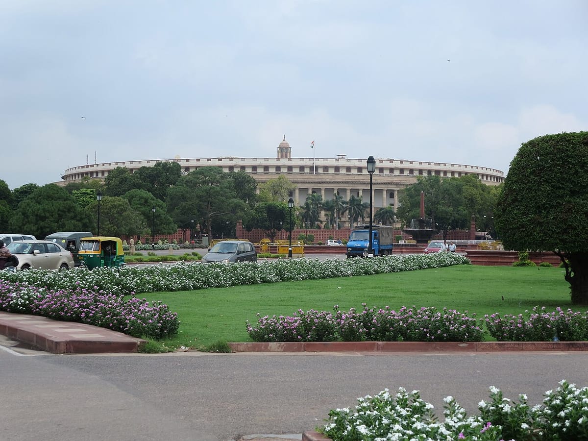 The round, pillared old Parliament House in New Delhi seen across a wide road from Vijay Chowk