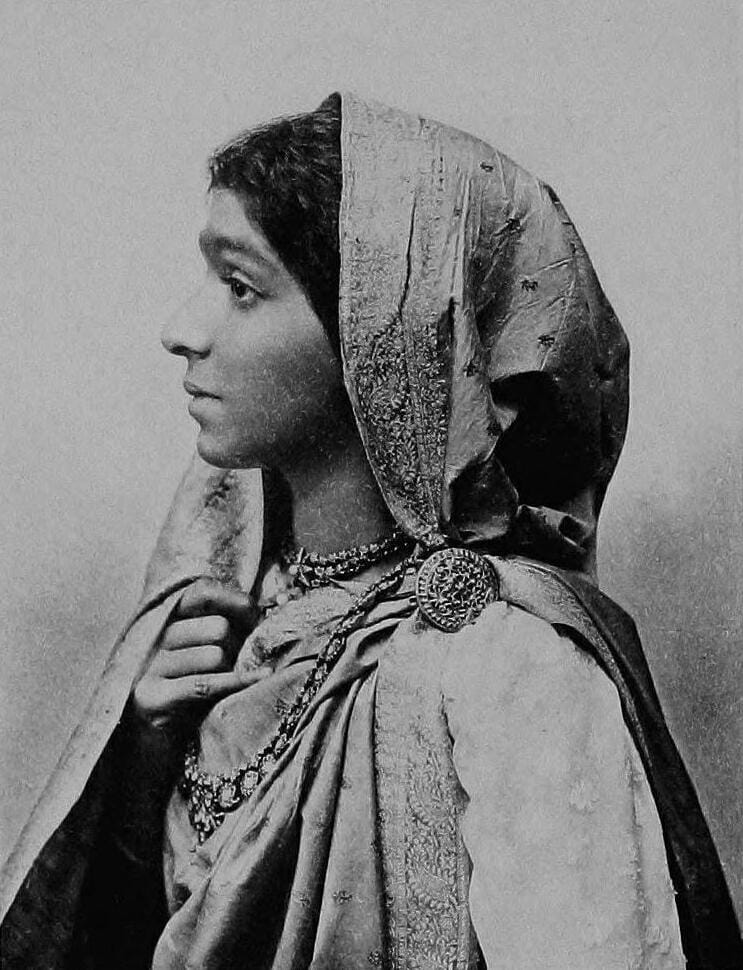 Black-and-white portrait of a young Sarojini Naidu with her hair tied back