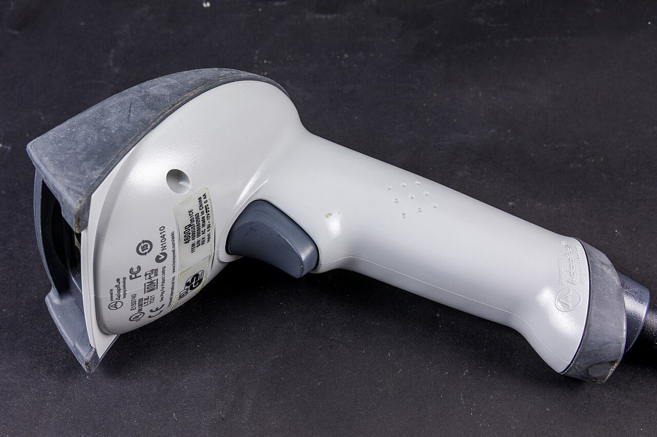 A black handheld barcode scanner shaped like a gun with a trigger