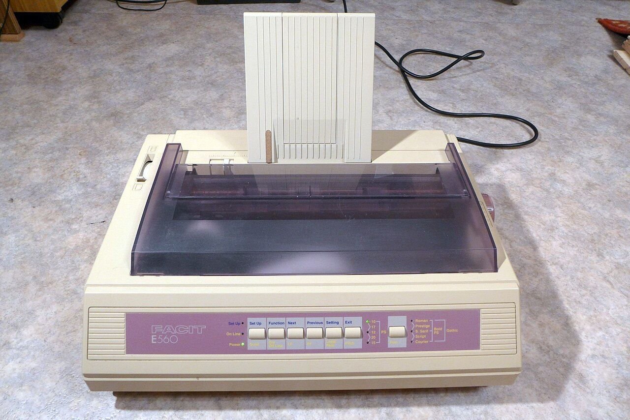 A beige office dot matrix printer with continuous paper feeding through it