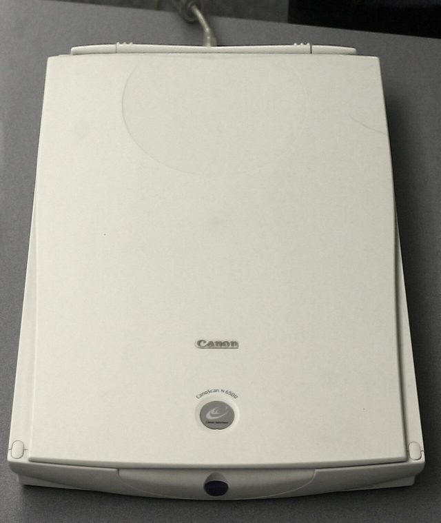 A flatbed image scanner with its lid open, showing the glass plate
