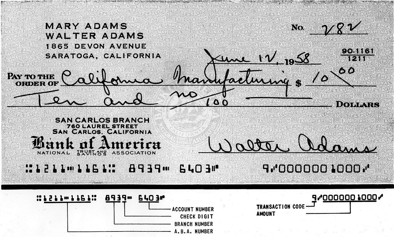 An old specimen bank cheque with a row of special magnetic-ink numbers along the bottom, labelled below