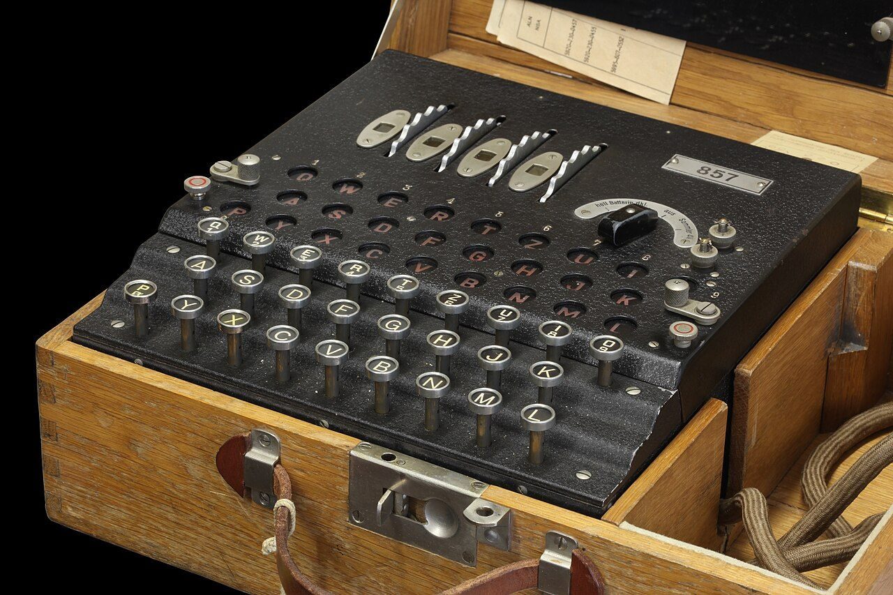 An old wooden cipher machine with a keyboard, lamp board and rotor wheels on top