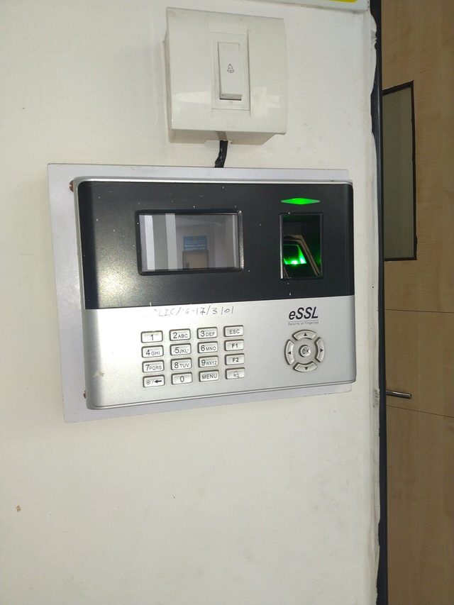 A small biometric fingerprint scanner with a glowing sensor pad