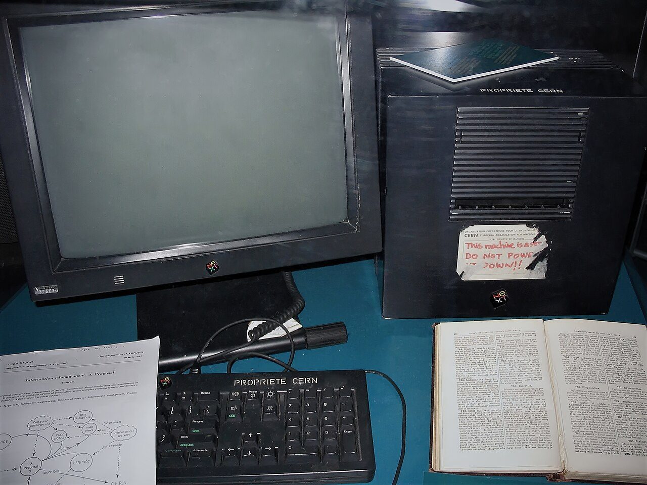A black NeXT computer and monitor on display in a glass case