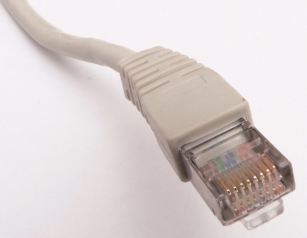 A clear plastic RJ45 plug with eight gold contacts on the end of a network cable