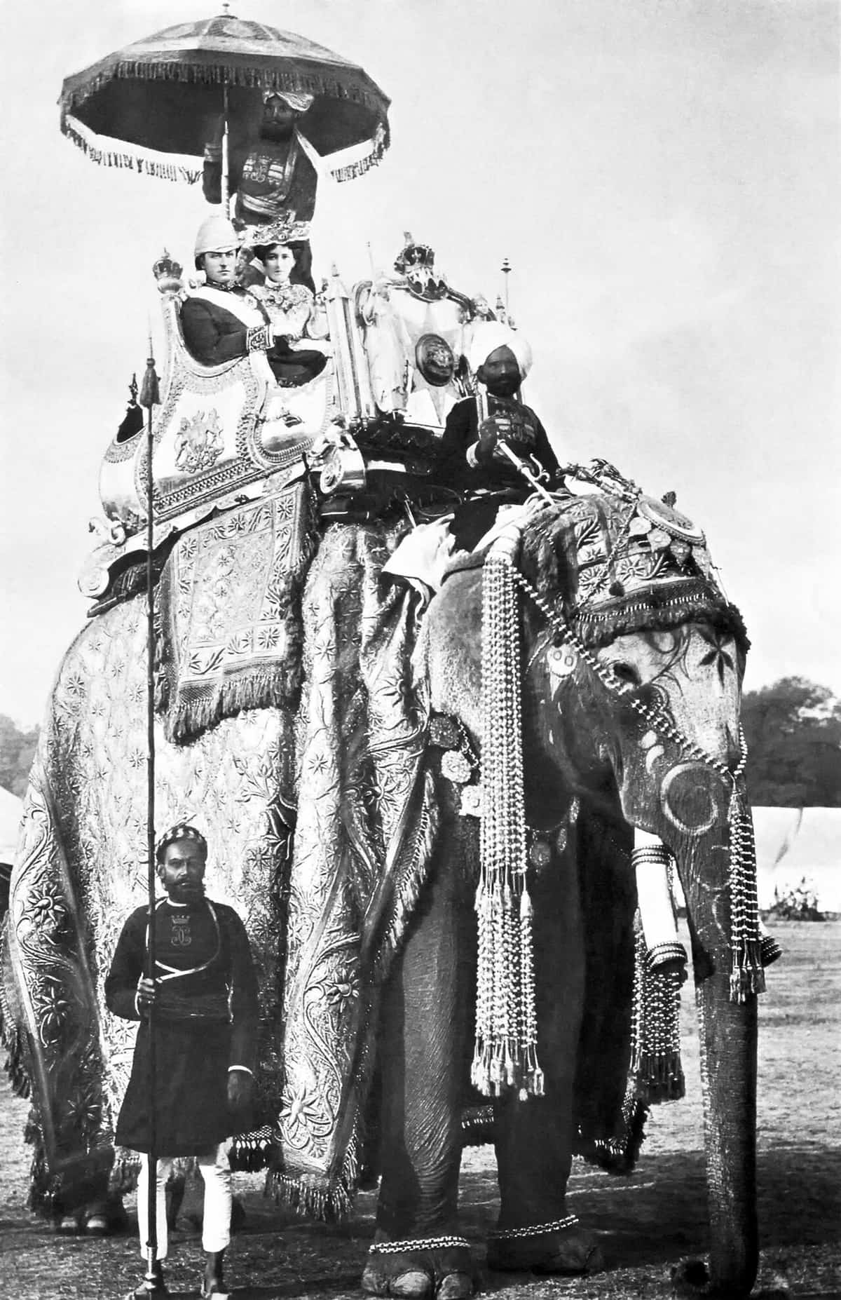 Old photograph of Lord and Lady Curzon in a decorated seat on a large elephant in a Delhi procession