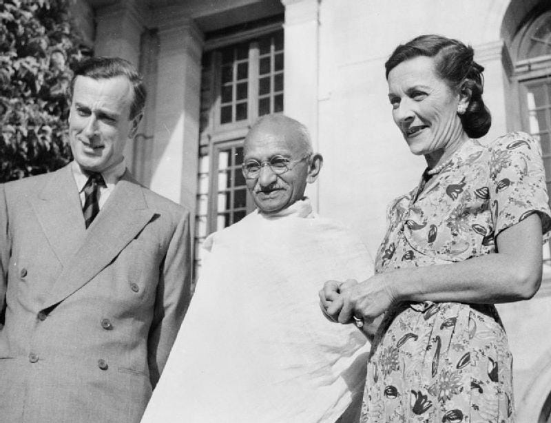 Black and white photograph of Lord and Lady Mountbatten standing with Mahatma Gandhi