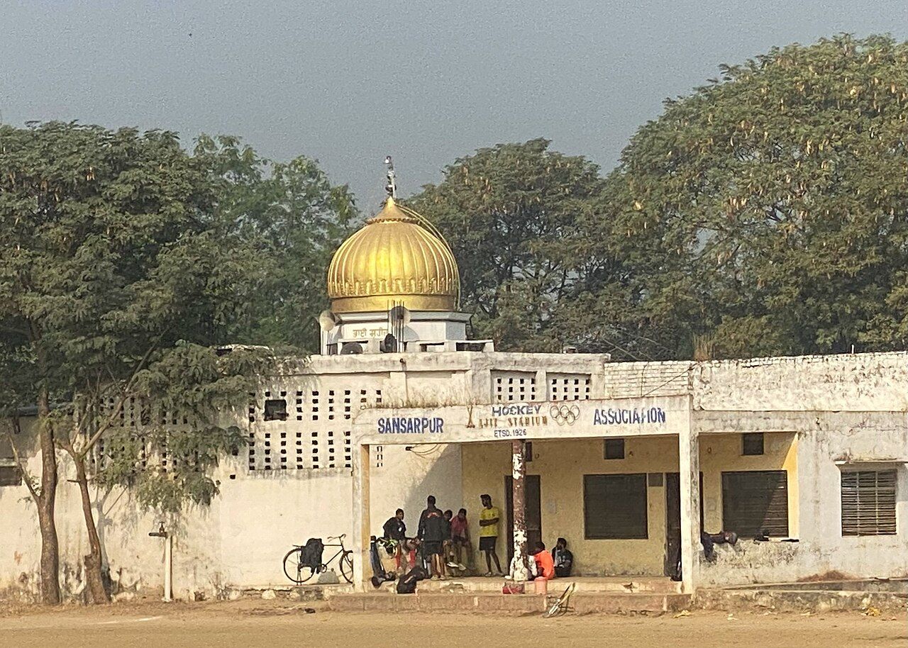 The whitewashed building of the Sansarpur Hockey Association, with a gurdwara dome behind it