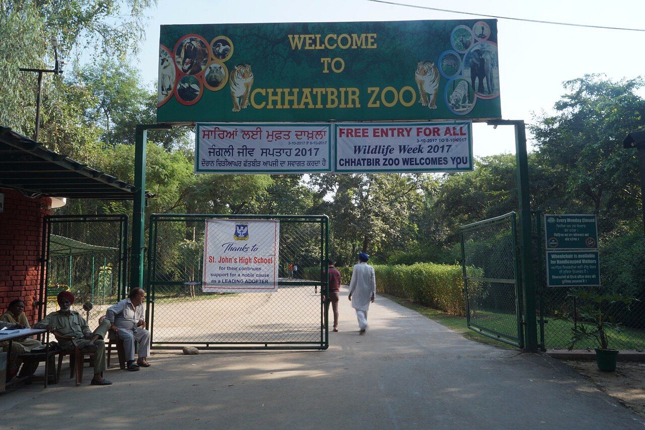 The green 'Welcome to Chhatbir Zoo' arch over the entrance gate, with visitors walking in