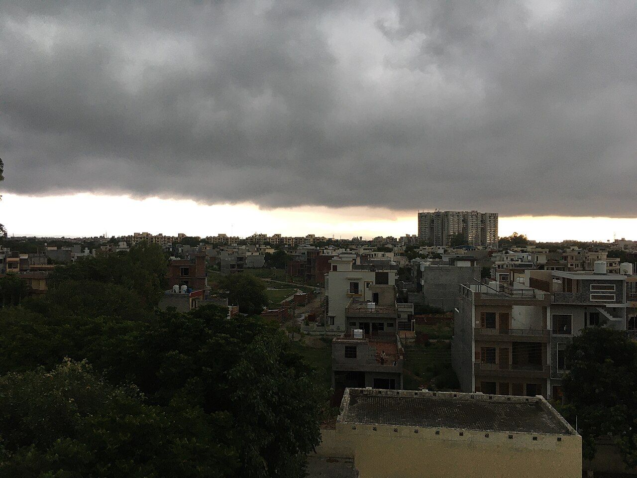 Dark monsoon clouds over the rooftops of a town