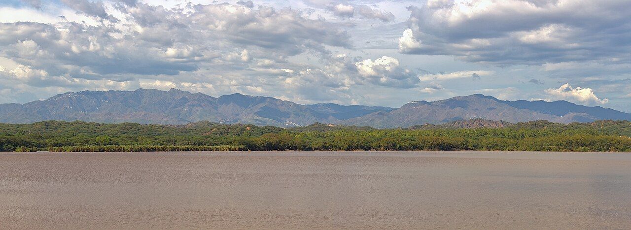 A low blue range of hills seen across the water of Sukhna Lake