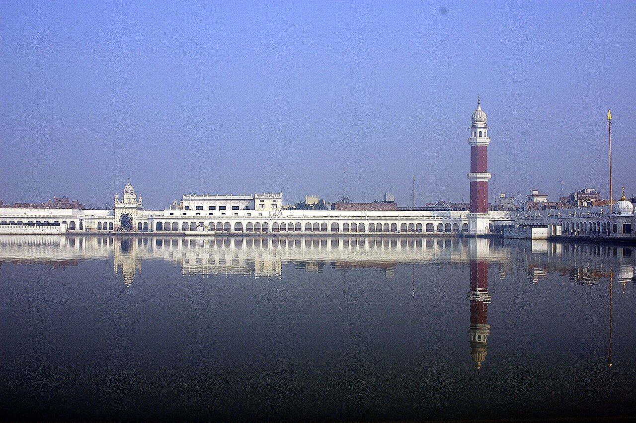 The large sarovar at Tarn Taran Sahib with a tall red-and-white minar