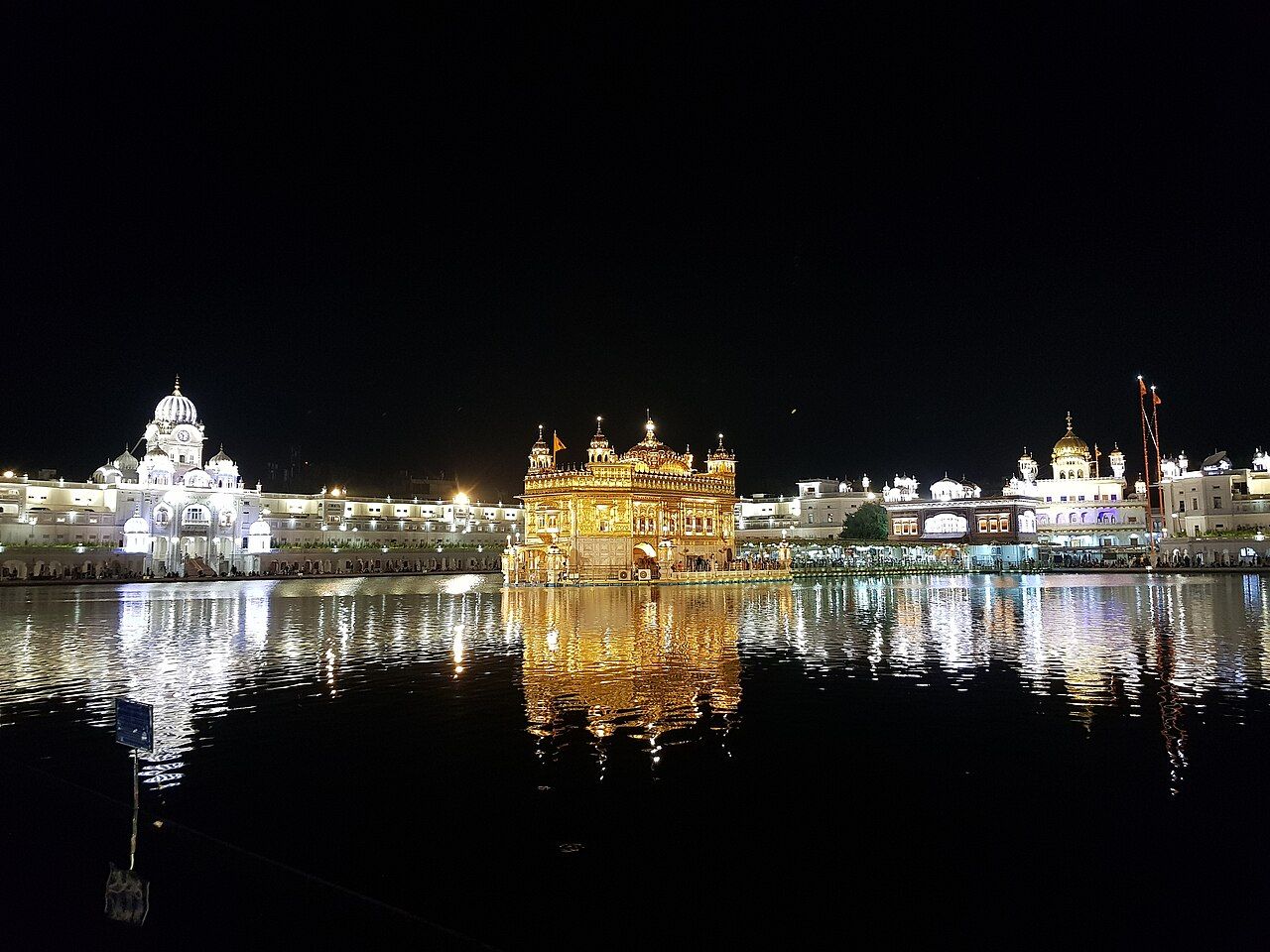Sri Harmandir Sahib lit up at night, reflected in the sarovar