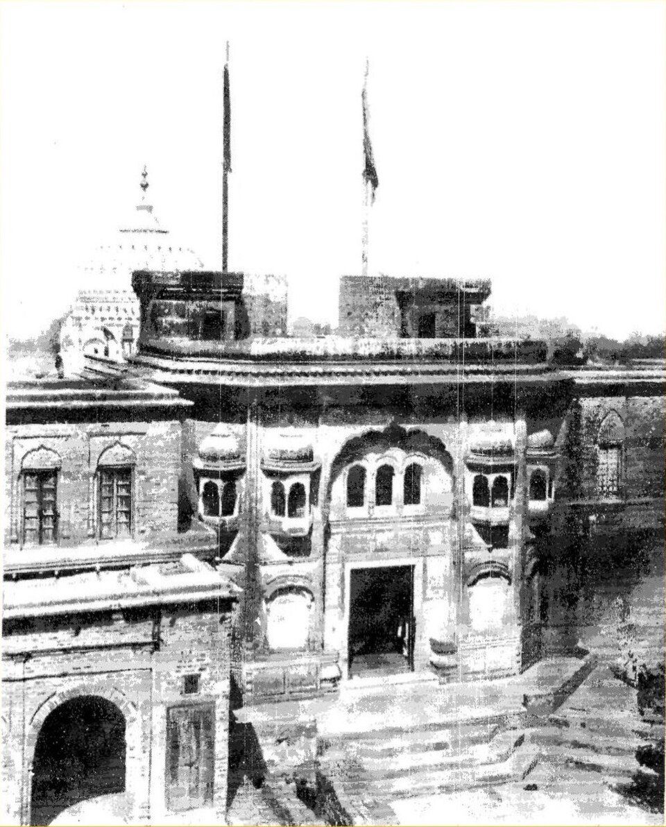 Old black-and-white photograph of the gurdwara building at Khadur Sahib with flagpoles