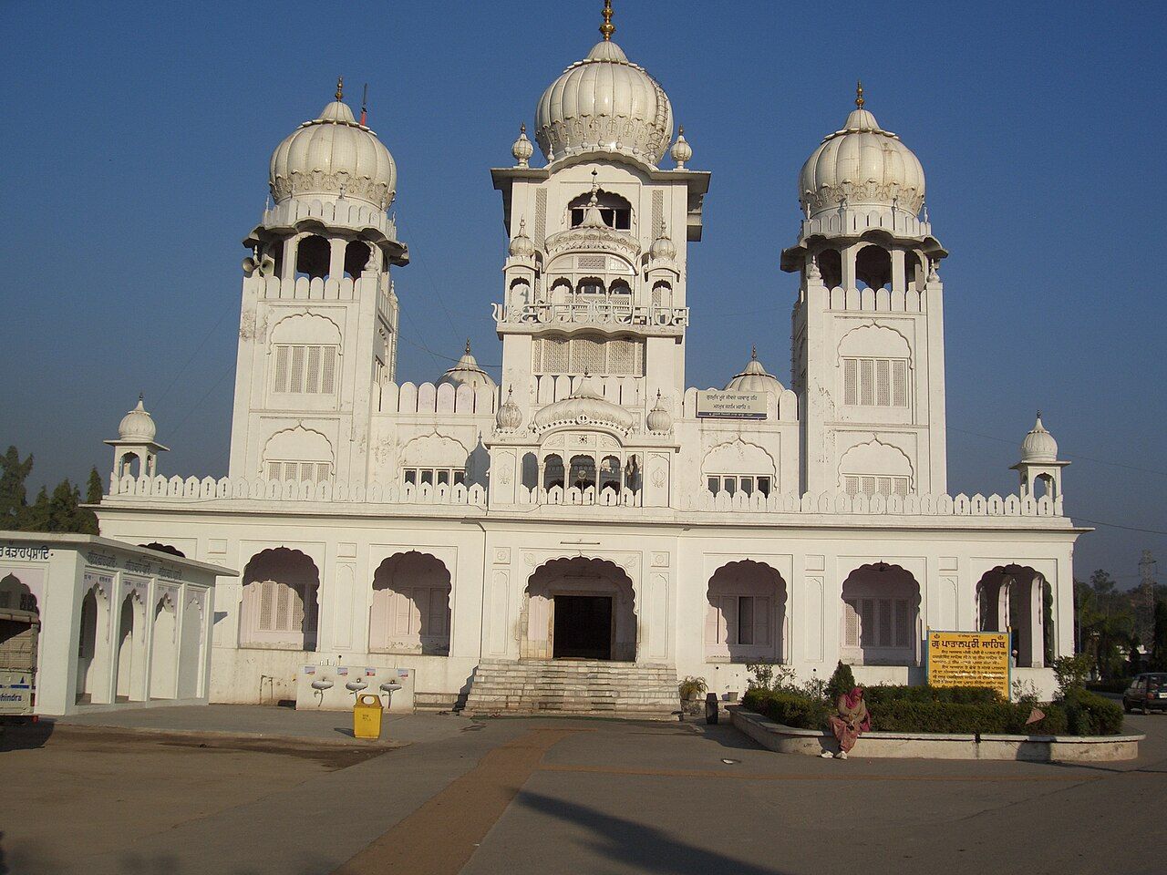 White gurdwara with three domes and arched verandas, Kiratpur