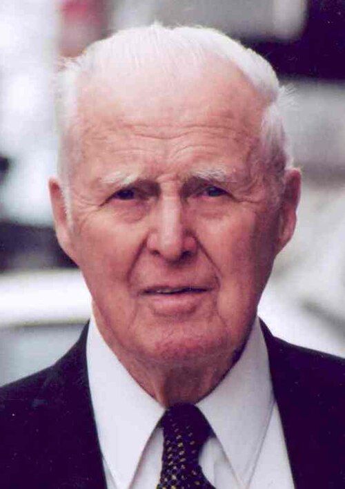 Photograph of Norman Borlaug, white-haired, in a suit and tie