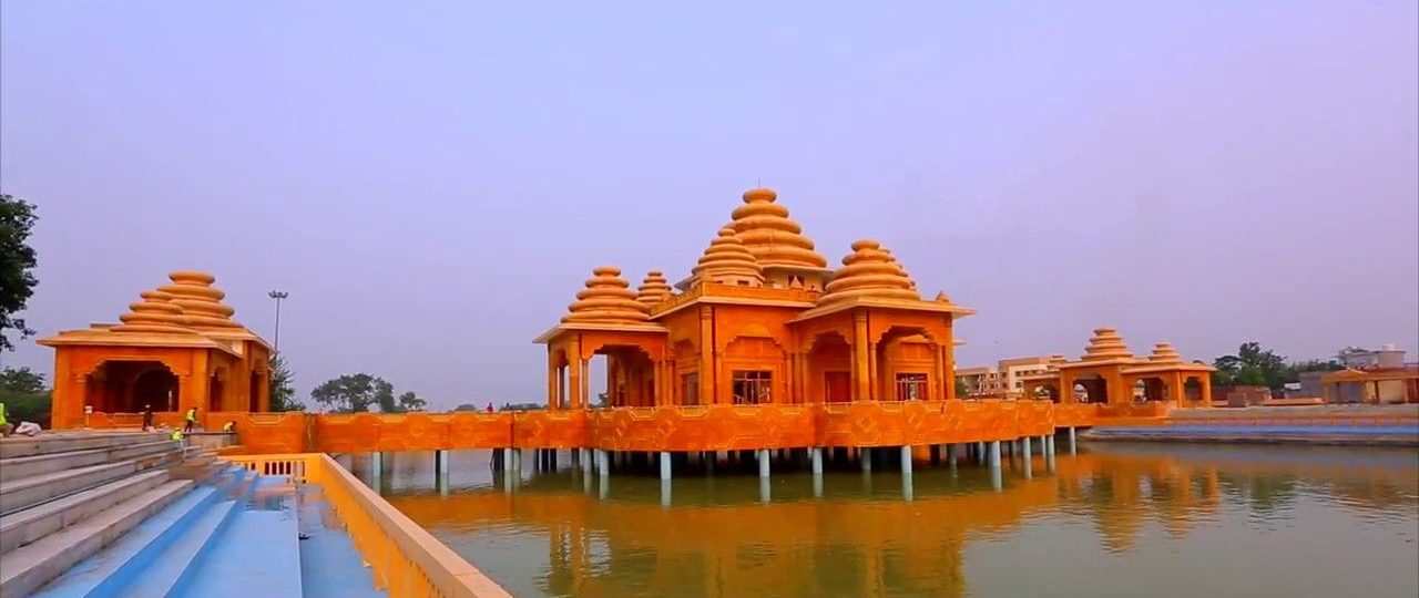 Orange temple pavilions standing in a large tank at Ram Tirath, near Amritsar