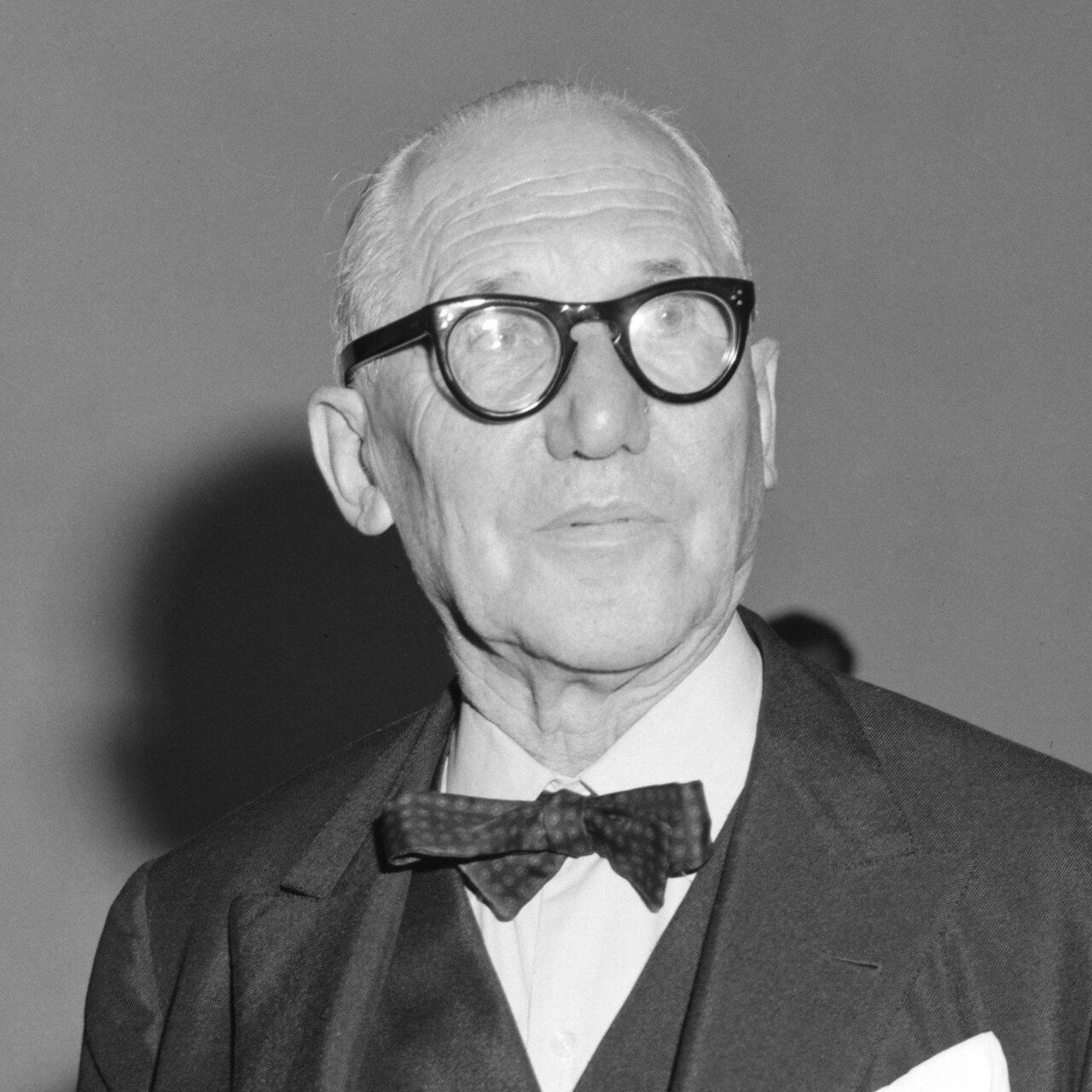 Black-and-white photo of an elderly man with round black glasses and a bow tie