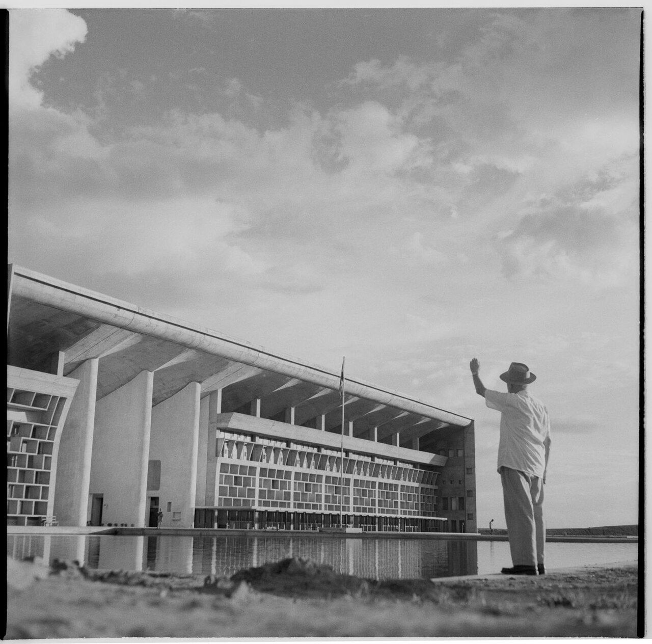 Old black-and-white photograph of the High Court building in Chandigarh, with a man in a hat waving